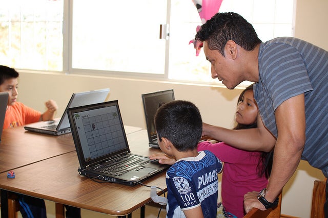 A teacher instructing a student on a donated laptop. A teacher instructing a student on a donated laptop.
