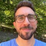 Blake Bertuccelli portrait in front of green leaves.