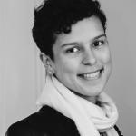 black and white head shot, short hair, wearing a scarf and leather jacket