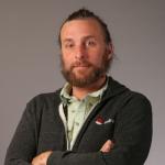 Tim Hildred stands with arms crossed. 