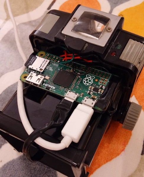 Inside of Brownie case showing the Raspberry Pi Zero board, USB power cable, and LED status indicators.