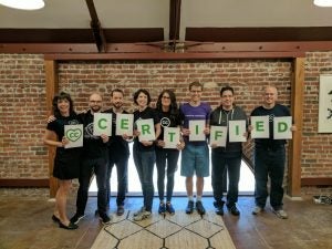 People holding signs reading CC Certified 